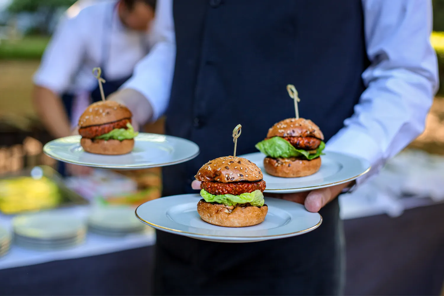 Ober serveert borden met hamburgers tijdens evenement

